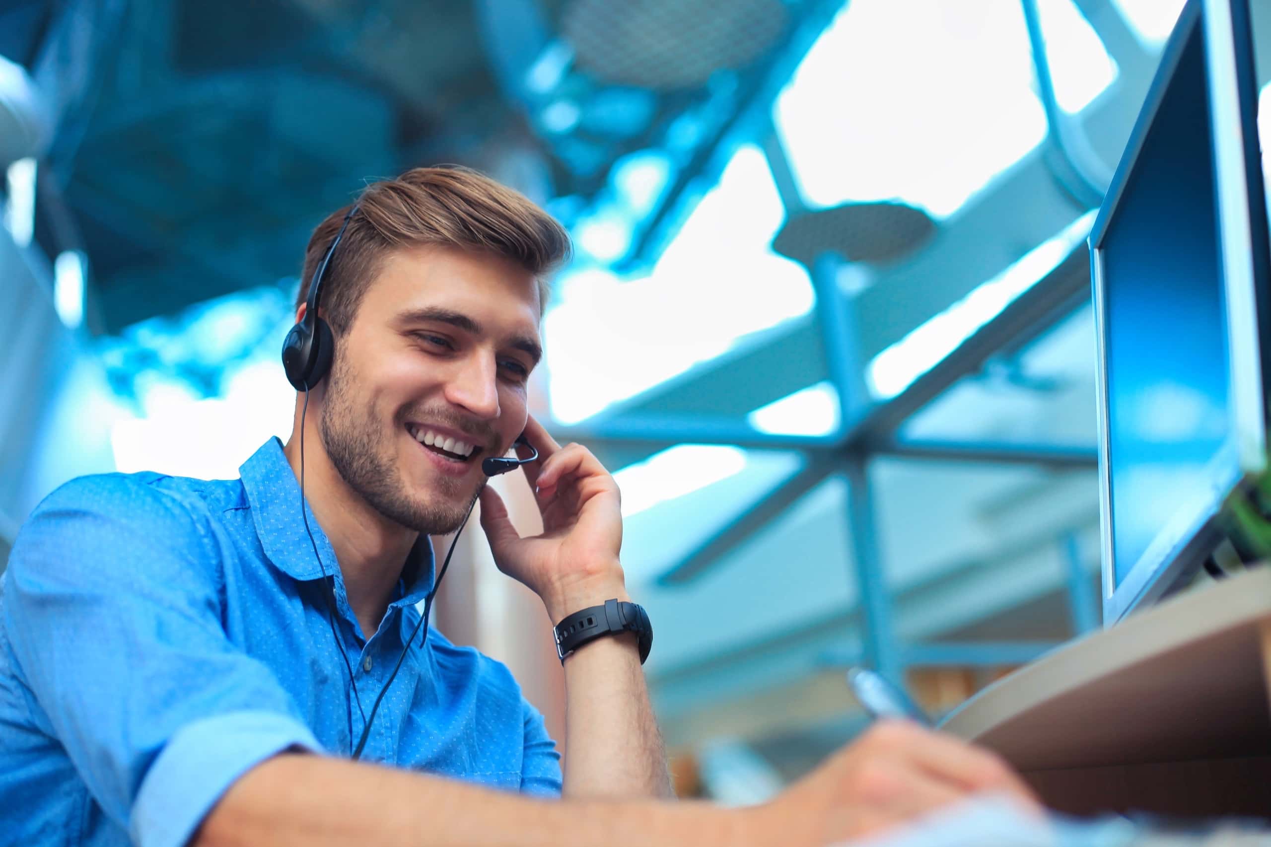 A smiling and friendly IT help desk technician wearing a headset, ready to provide fast and efficient support to end users, ensuring smooth operation of their devices.