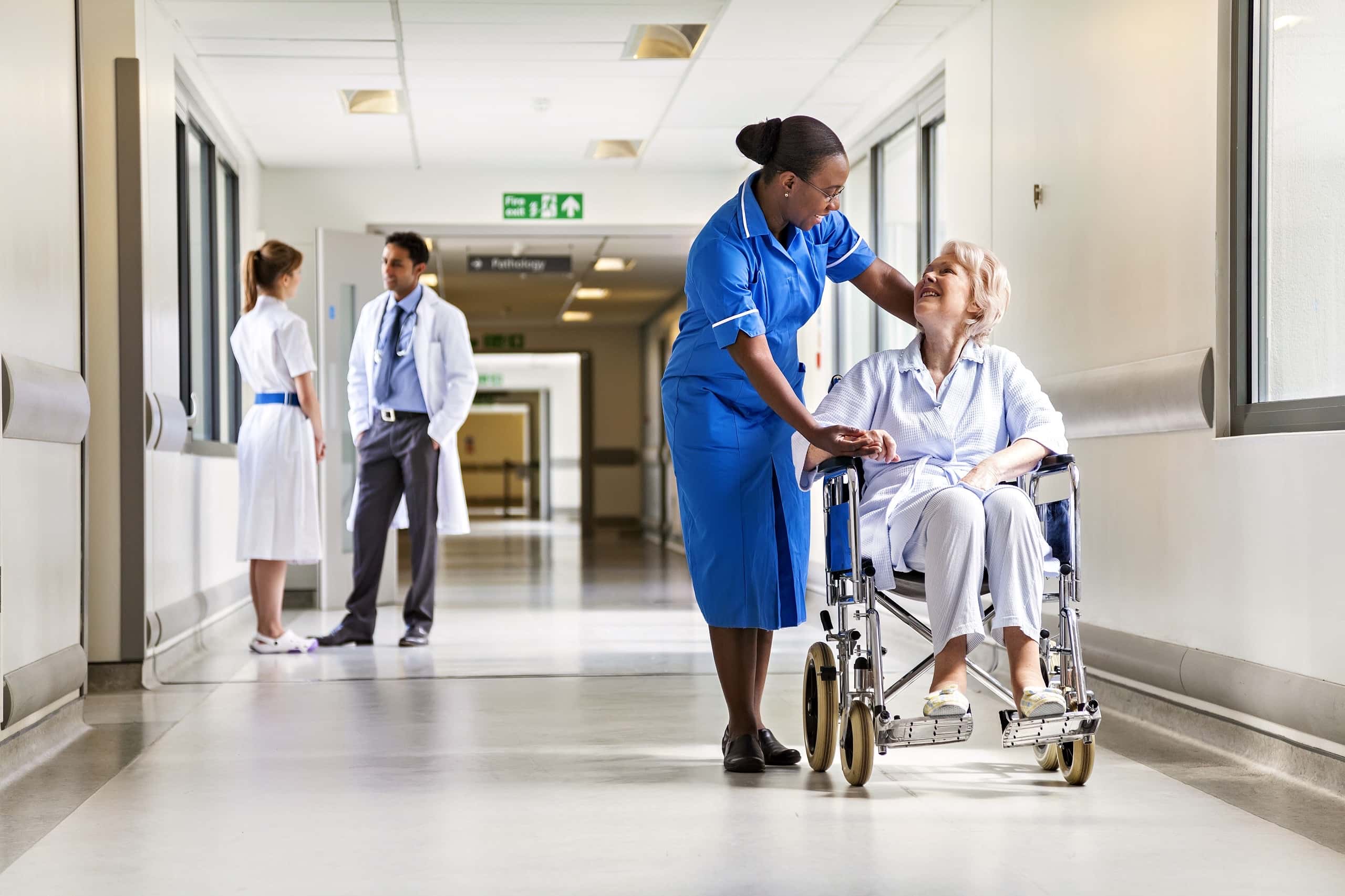 A nurse pushing a patient in a wheelchair, symbolizing Fast Fixx's commitment to optimizing healthcare operations