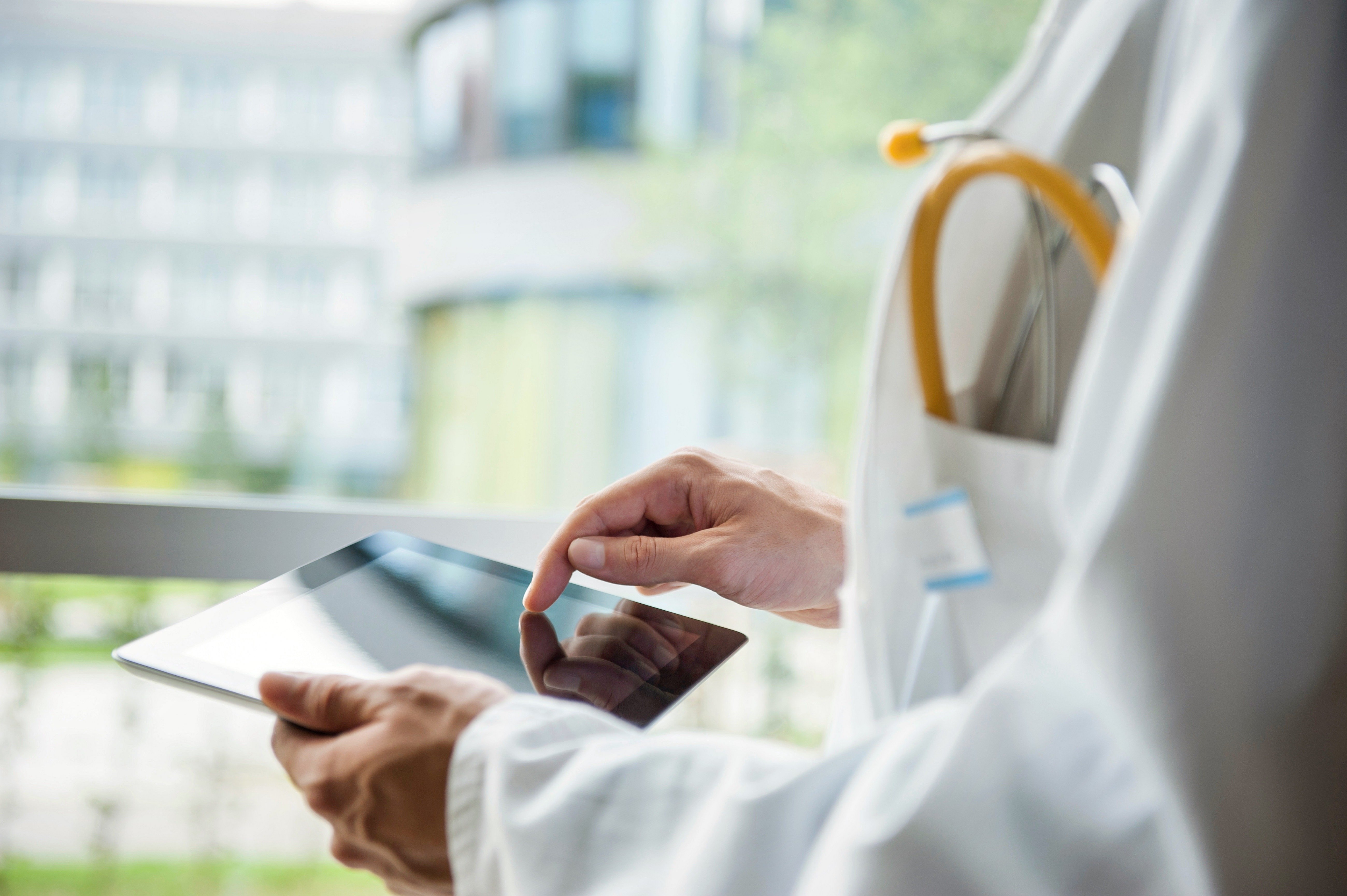 A doctor touching a HIPAA compliant tablet device