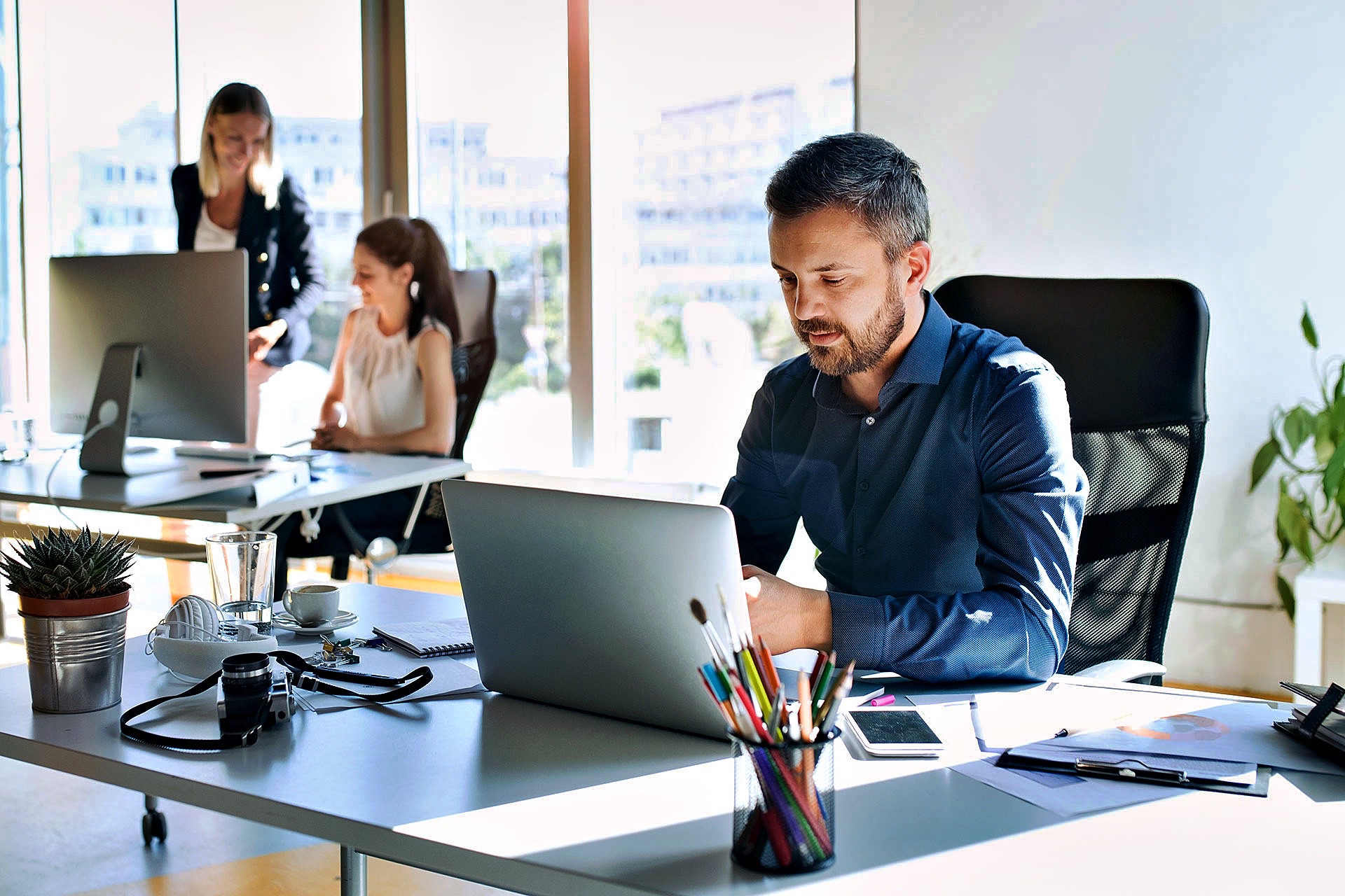 Two business colleagues discussing IT solutions while looking at a laptop, representing the proactive and comprehensive managed IT services offered by Fast Fixx